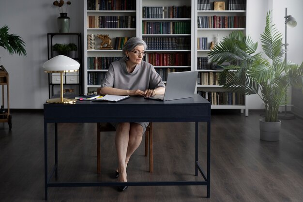 Mujer de tiro completo que trabaja en el escritorio