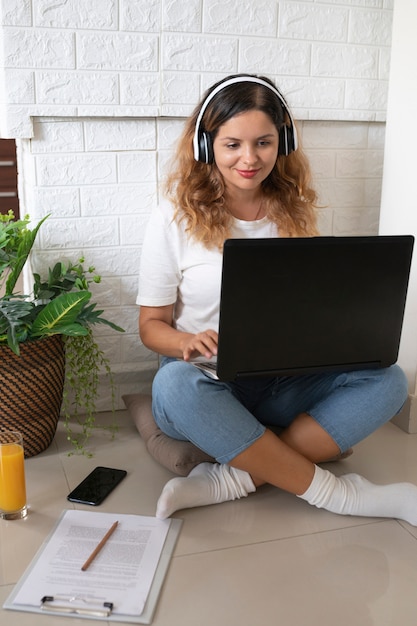 Mujer de tiro completo que trabaja con el portátil