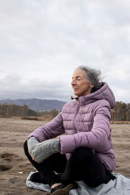 Mujer de tiro completo sentada en la naturaleza