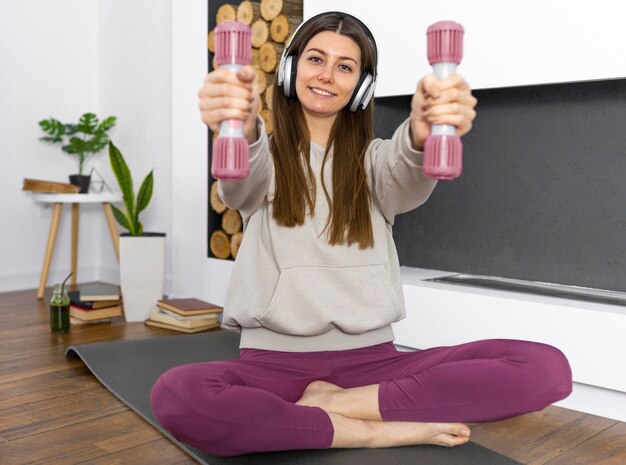 Mujer de tiro completo sosteniendo pesas