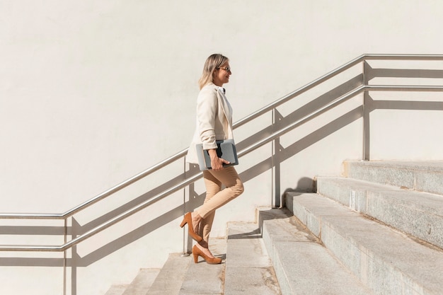 Mujer de tiro completo subiendo escaleras