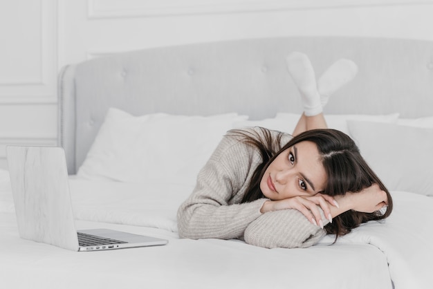 Mujer de tiro completo tendido en la cama