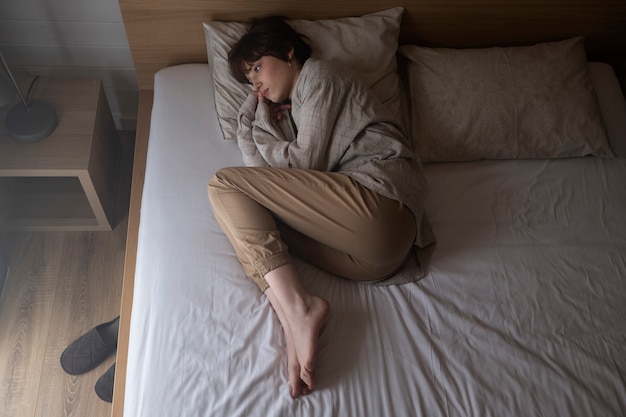 Mujer de tiro completo tendido en la cama