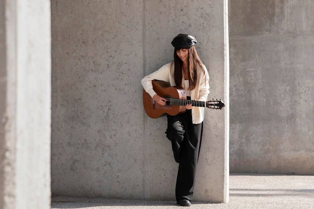 Mujer de tiro completo tocando la guitarra