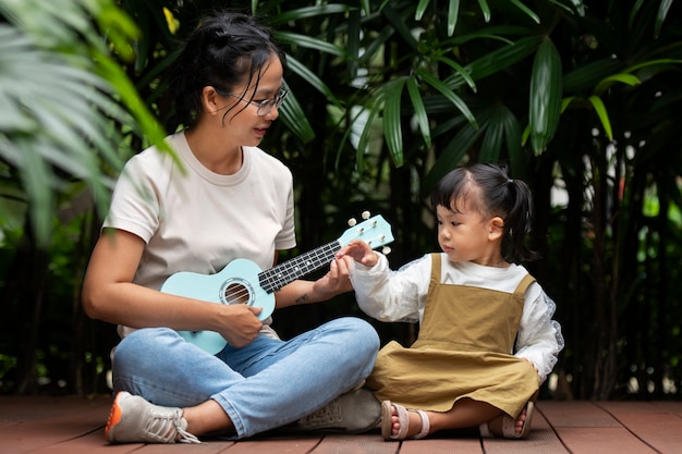 Foto gratuita mujer de tiro completo tocando el ukelele