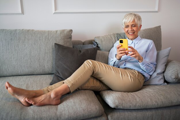 Mujer de tiro completo tomando un descanso con teléfono inteligente