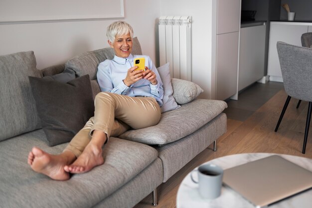 Mujer de tiro completo tomando un descanso con teléfono inteligente