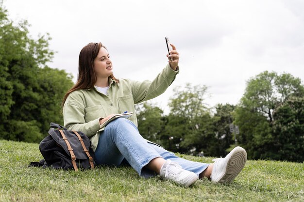 Mujer de tiro completo tomando selfie