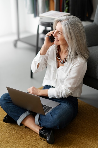 Mujer de tiro completo trabajando en la computadora portátil dentro