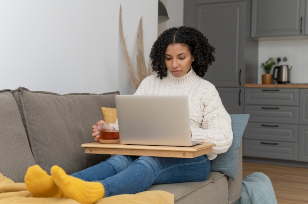 Mujer de tiro completo trabajando en la computadora portátil