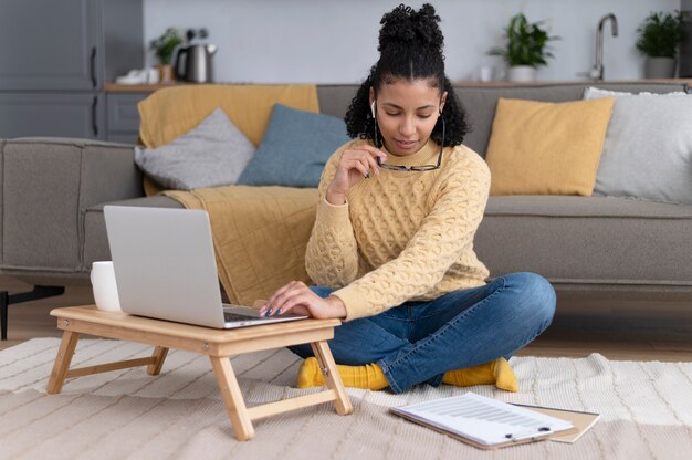 Mujer de tiro completo trabajando en equipo portátil