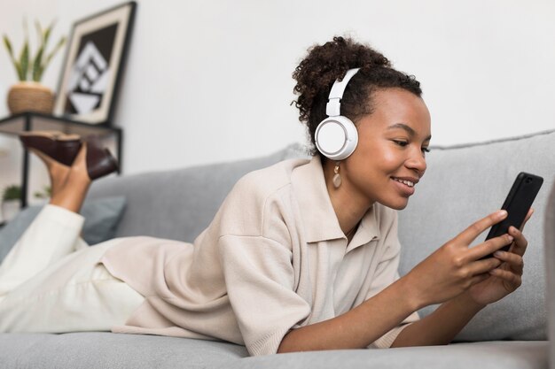 Mujer de tiro completo usando audífonos