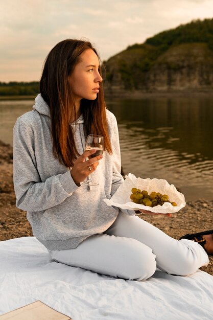 Mujer de tiro completo con uvas y vino.