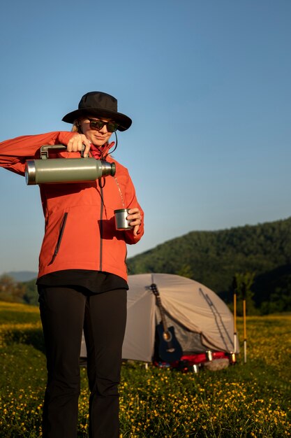 Mujer de tiro completo vertiendo agua en una taza