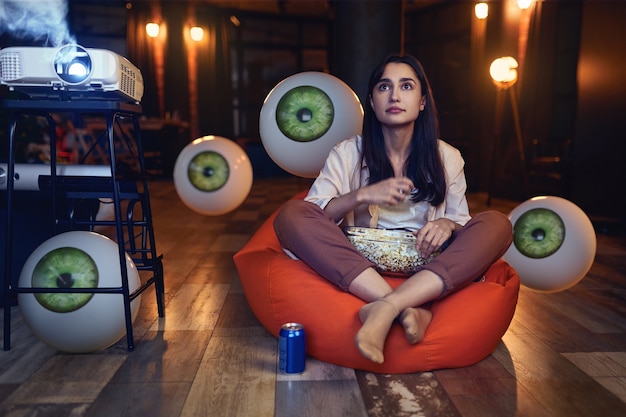 Mujer de tiro completo viendo una película en casa