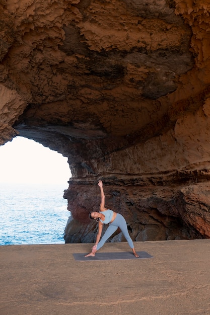 Foto gratuita mujer de tiro largo haciendo pose de yoga