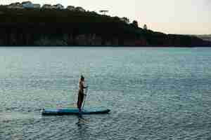 Foto gratuita mujer de tiro largo paddleboarding