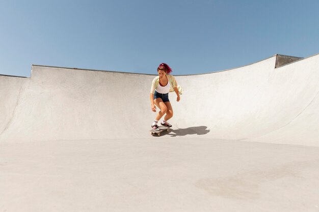 Mujer de tiro largo en patineta