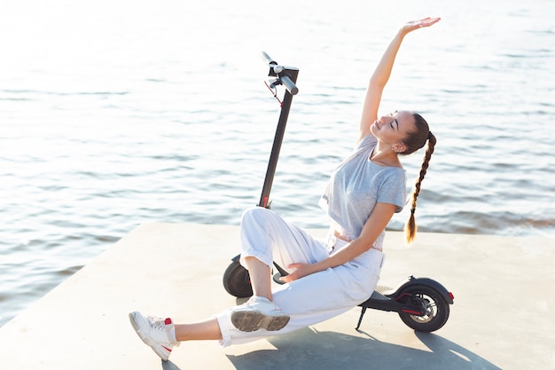 Foto gratuita mujer de tiro largo posando en scooter