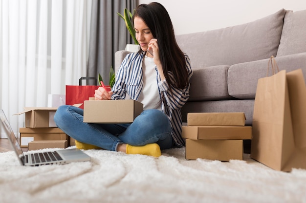 Mujer de tiro largo sosteniendo un paquete de cyber monday