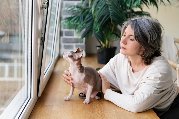 Mujer de tiro medio acariciando gato