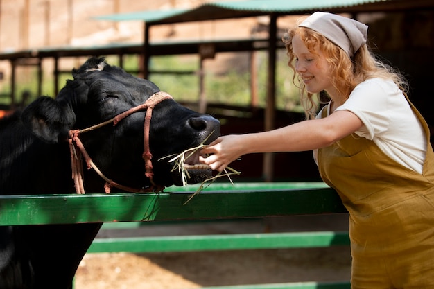 Mujer de tiro medio alimentando animal