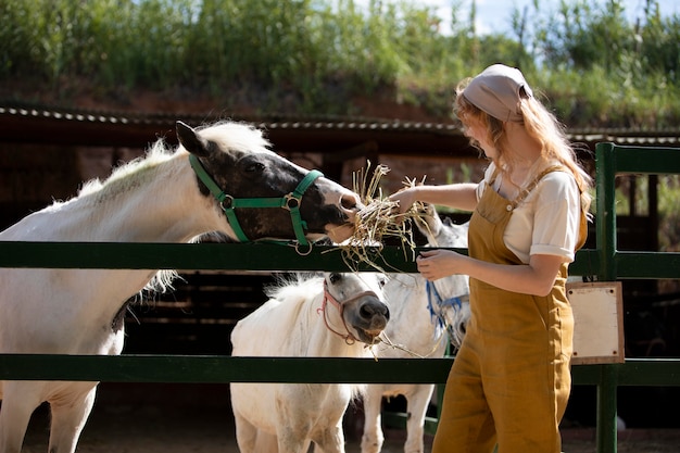 Mujer de tiro medio alimentando animales