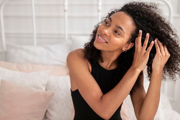 Mujer de tiro medio aplicar producto para el cabello