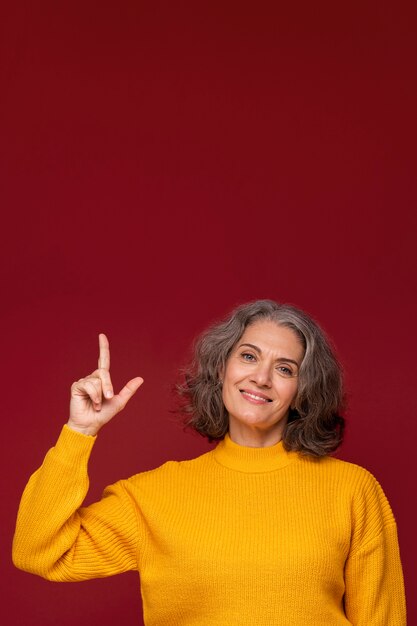 Mujer de tiro medio apuntando hacia arriba