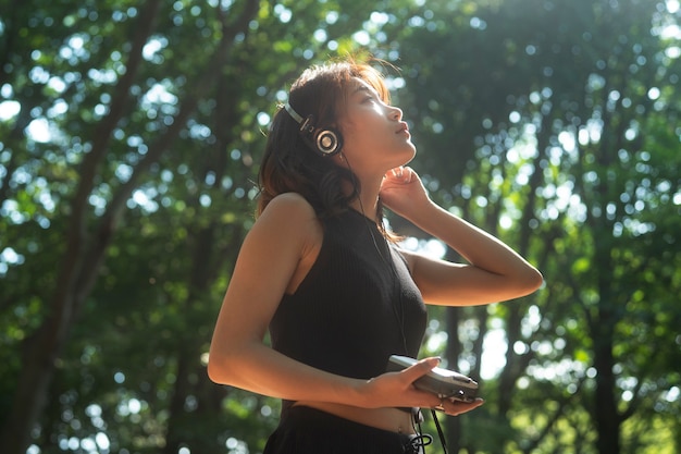 Mujer de tiro medio con auriculares al aire libre