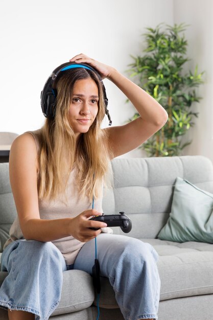 Mujer de tiro medio con auriculares en el sofá