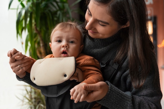 Foto gratuita mujer de tiro medio con bebé en portabebés