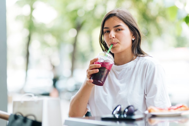 Mujer de tiro medio bebiendo jugo