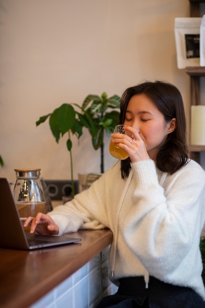 Foto gratuita mujer de tiro medio bebiendo kombucha