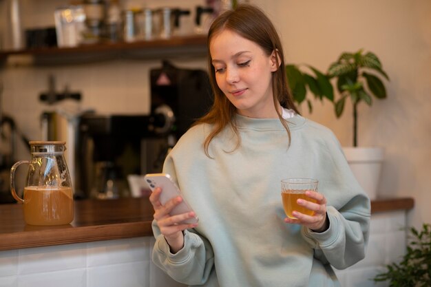 Foto gratuita mujer de tiro medio bebiendo kombucha