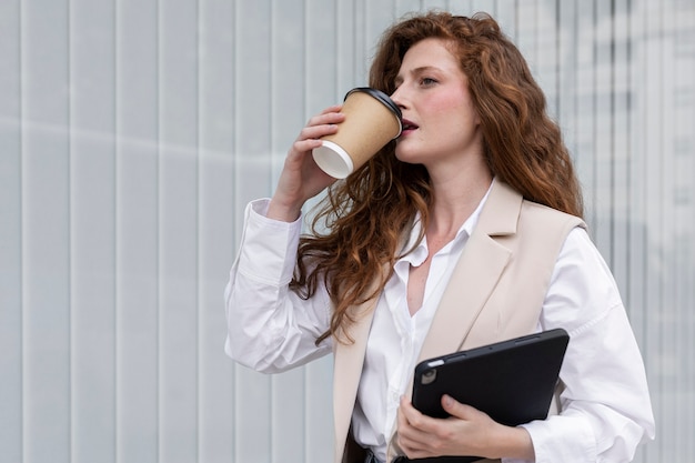Mujer de tiro medio bebiendo una taza de café