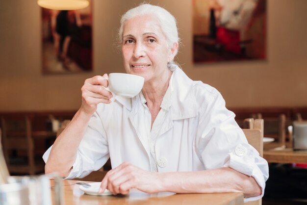 Mujer de tiro medio bebiendo té en el restaurante