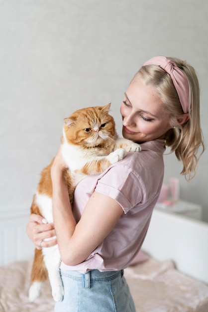 Mujer de tiro medio besando a gato