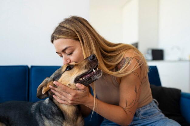 Mujer de tiro medio besando a perro