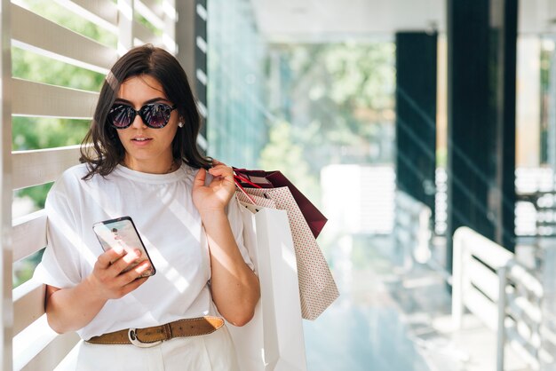 Mujer de tiro medio buscando en el teléfono.