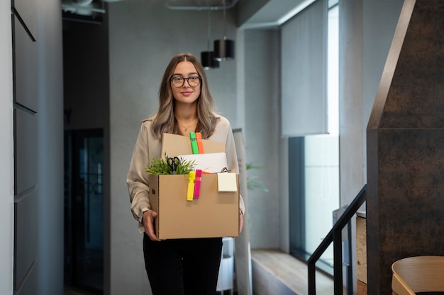 Mujer de tiro medio con caja de cartón.