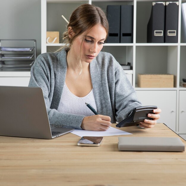 Mujer de tiro medio con calculadora