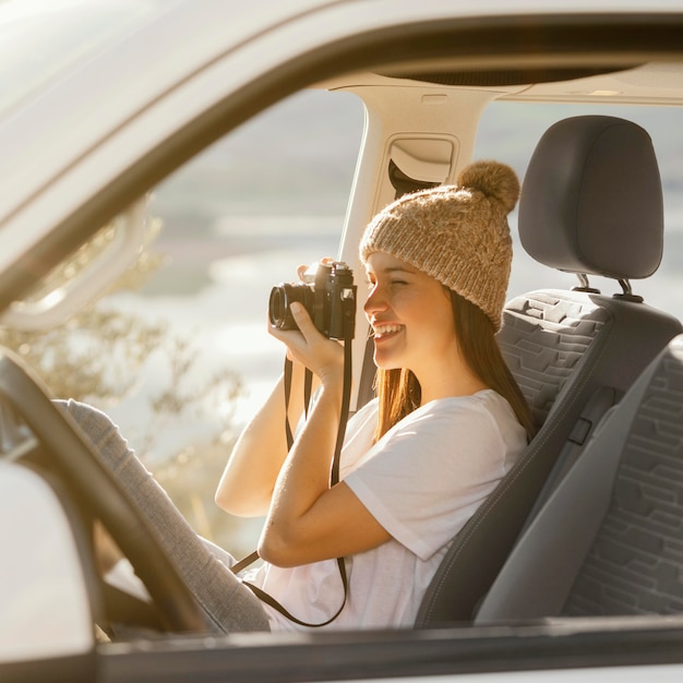 Mujer de tiro medio con cámara de fotos