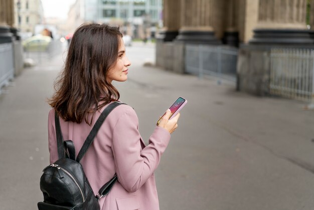 Mujer de tiro medio caminando con teléfono