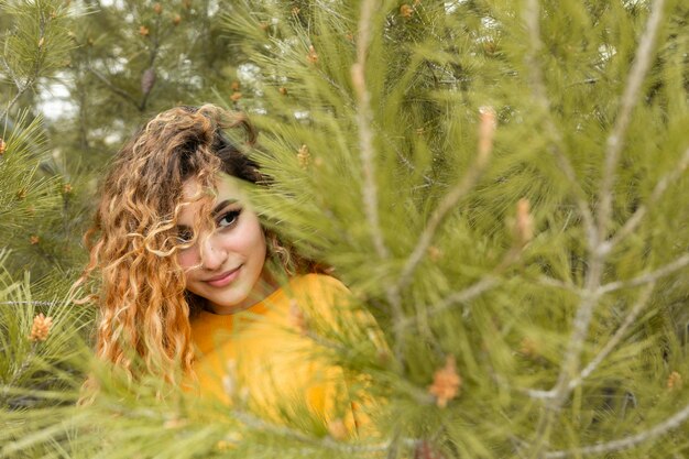 Mujer de tiro medio cerca del árbol