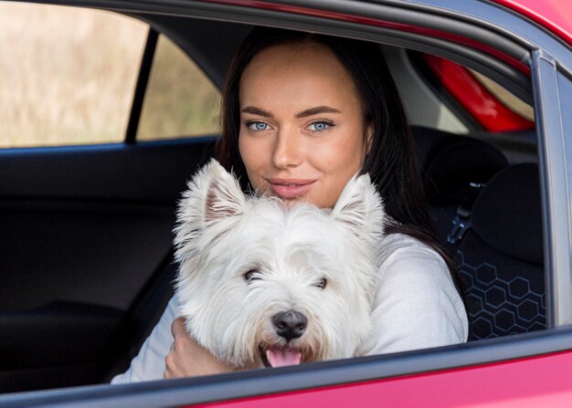 Mujer de tiro medio en coche con perro