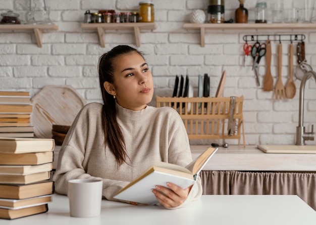 Foto gratuita mujer de tiro medio en la cocina leyendo