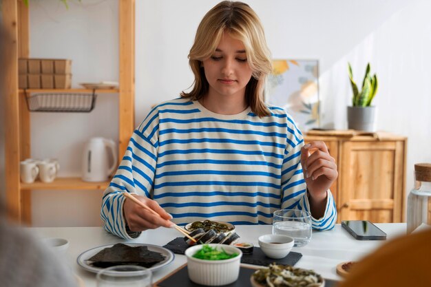 Mujer de tiro medio comiendo en casa