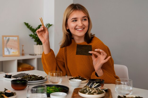 Mujer de tiro medio comiendo en casa