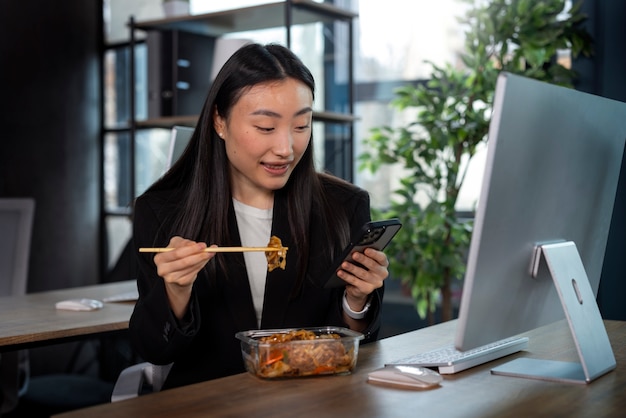 Foto gratuita mujer de tiro medio comiendo comida asiática